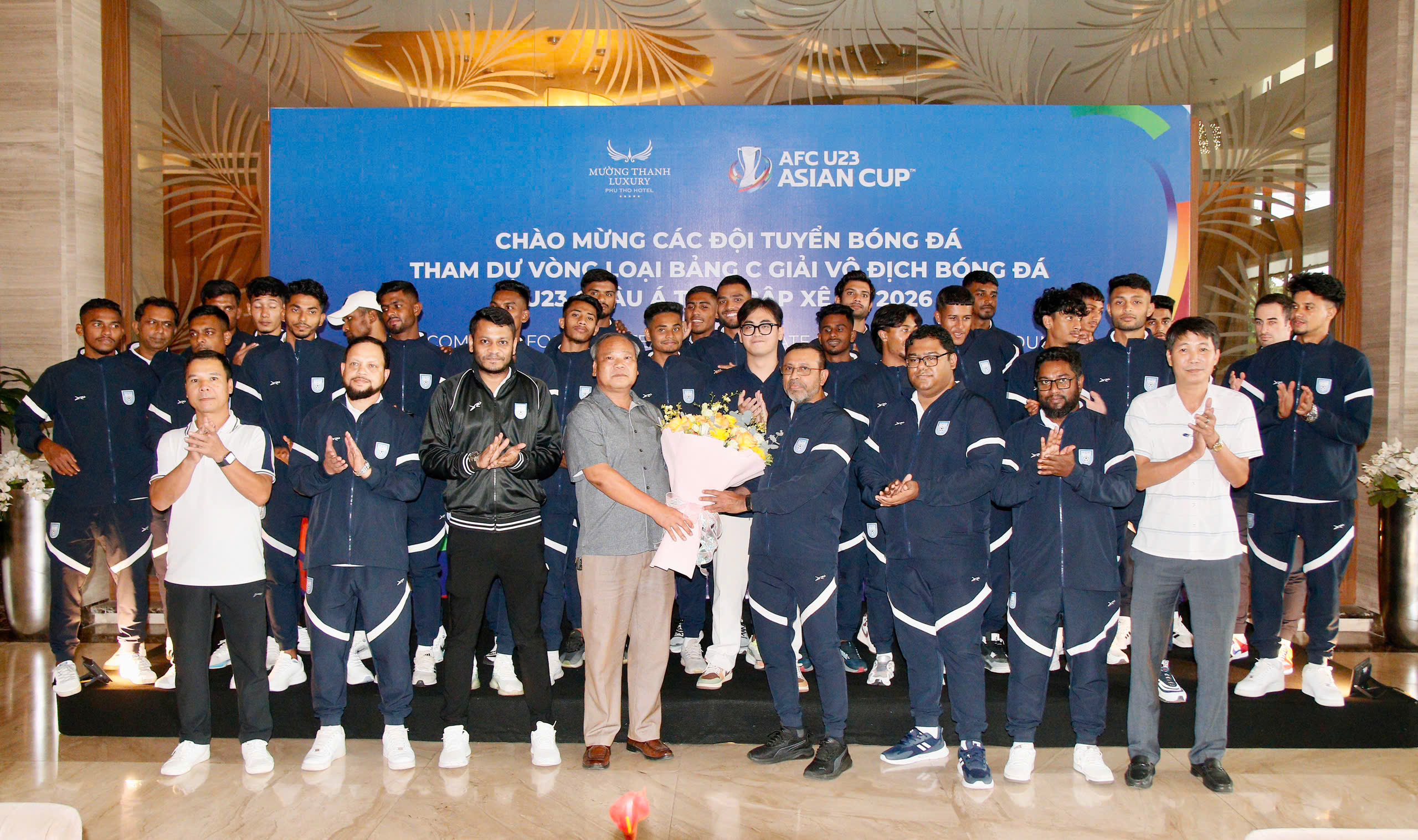 HLV Saiful Bari Titu của U23 Bangladesh (đeo kính, cầm hoa) bị sốt